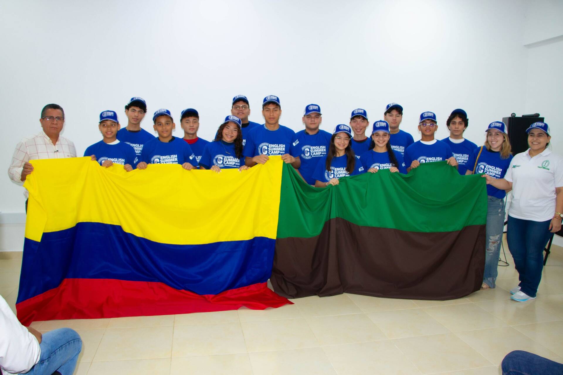 El rector Jairo Torres Oviedo entregó simbólicamente las banderas de Colombia y de la Universidad de Córdoba a los estudiantes que participarán en el campamento de verano en Reino Unido, acompañados por sus padres y directivos del Centro de Idiomas.